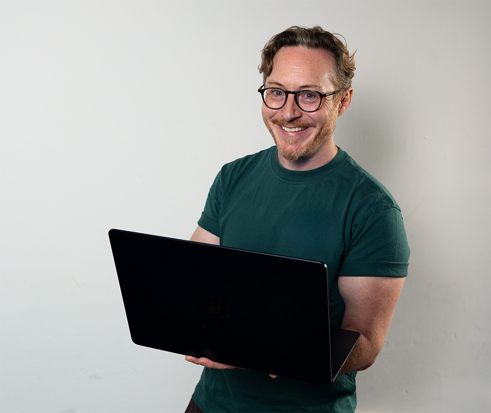 Man holding laptop and smiling